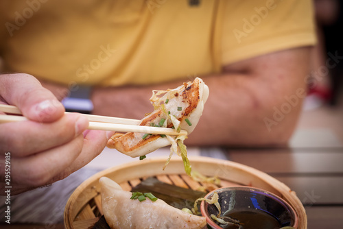 Thai food. mixed chicken, shrimp and vegetable gyozas in a Thai steamer with soy sauce in a black bowl photo