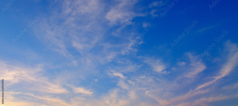 Fluffy clouds in the blue sky. Wide photo.