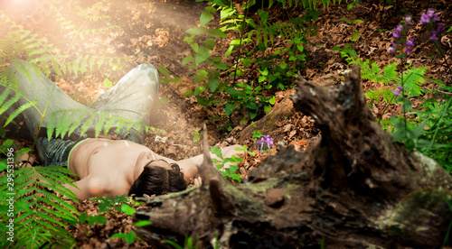Young man lying on the floor of a forest