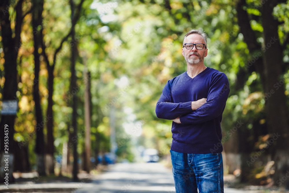 Handsome middle age man with gray hair in an outdoor setting. Handsome middle age man with gray hair in an outdoor setting.