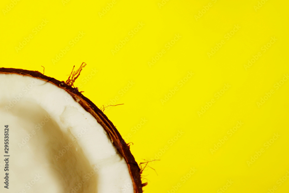 Half coconut on a yellow background. Abstract colorful background of food. Half coconut on a yellow background. Abstract colorful background of food.