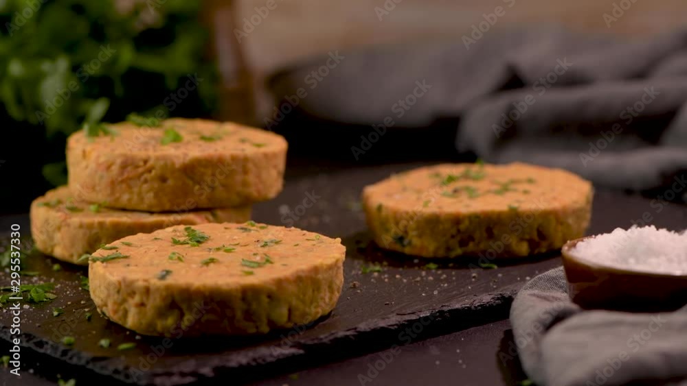 Raw veggie burger with chickpeas and vegetables with parsley leaves on kitchen countertop. Raw veggie burger with chickpeas and vegetables with parsley leaves on kitchen countertop.