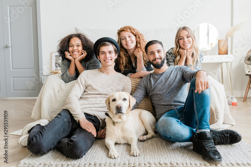 Two smiling guys with white labrador and pretty girls relaxing at leisure © pressmaster