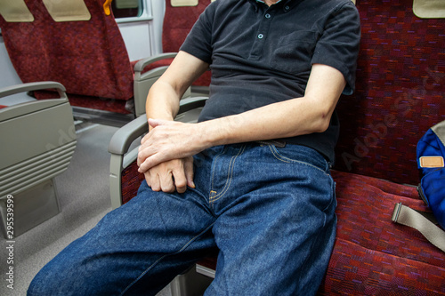 電車の椅子に座る男性 © decoplus