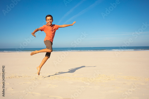 Boy jump and dance on the sand sea beach