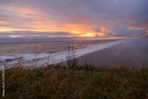 Sunset at the southcoast of iceland. Fantastic view over the foggy black sand at the beach