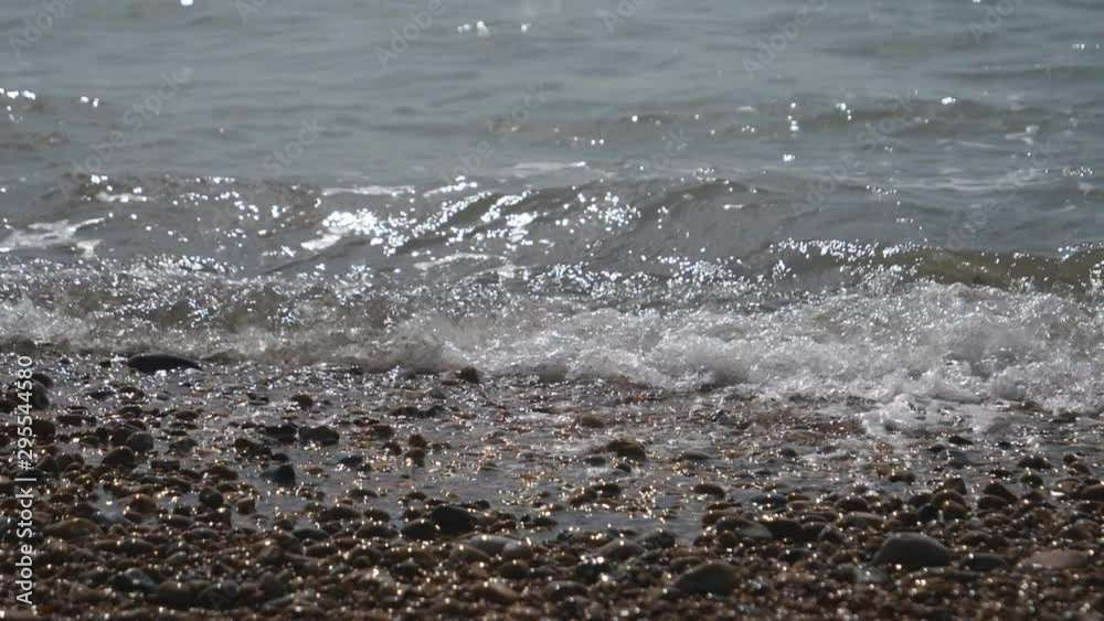 Slow Motion. Sea waves splashing on a pebble shore. Slow Motion. Sea waves splashing on a pebble shore.