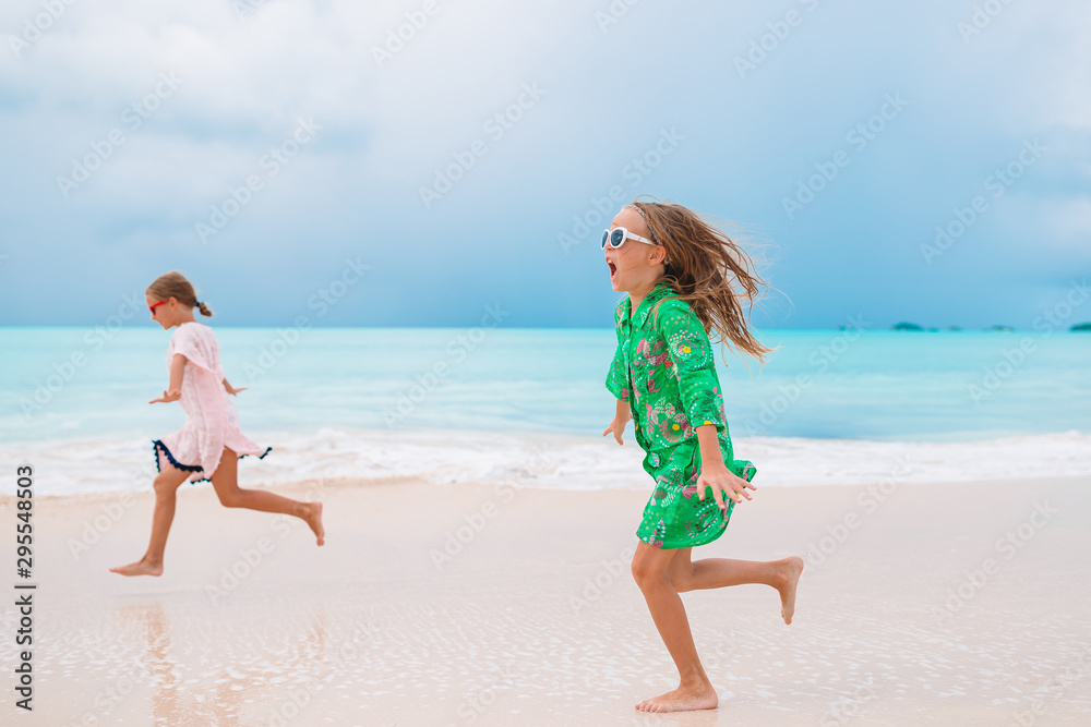 Fototapeta premium Little girls having fun enjoying vacation on tropical beach