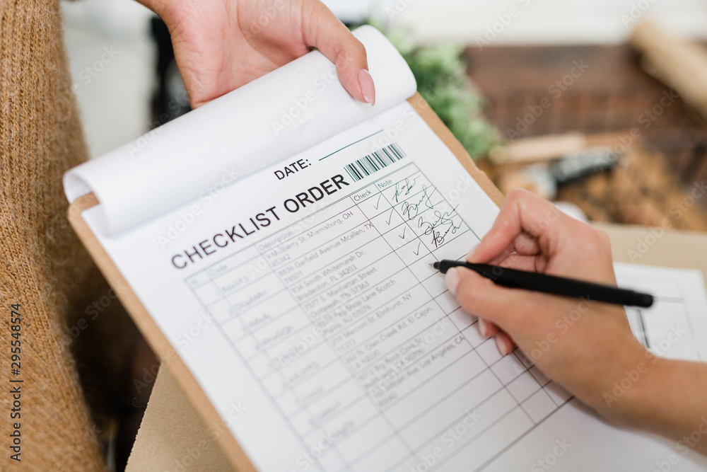 Woman with pen going to put tick opposite one of ordered items in checklist