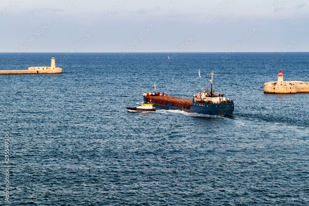 Fototapeta premium Cargo ship at the entrance to Grand Harbour in Malta
