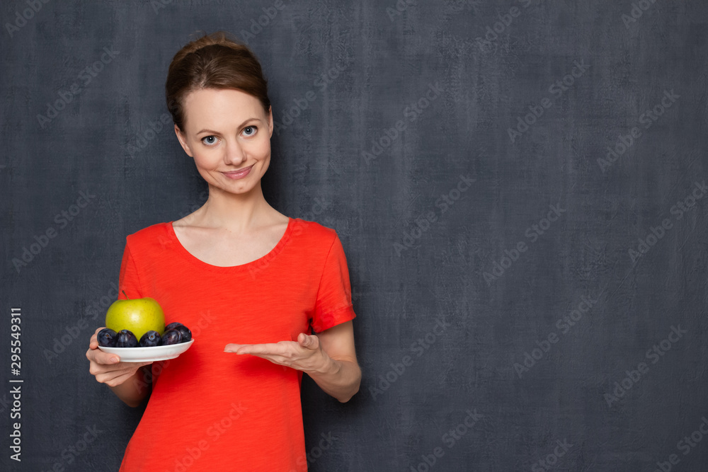 Portrait of happy pretty girl offering to taste plums and apple Portrait of happy pretty girl offering to taste plums and apple