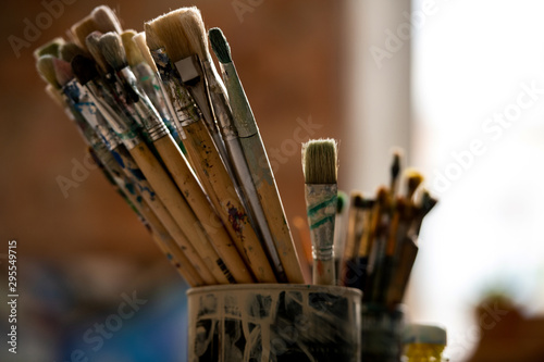 Set of paintbrushes for professional painting in tin can inside modern studio