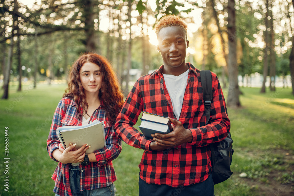 Two students with books poses in summer park Two students with books poses in summer park