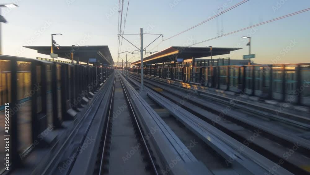 Driverless Train approaching elevated metro station platform looking from inside the front of the train in the afternoon sun. Sydney Australia.