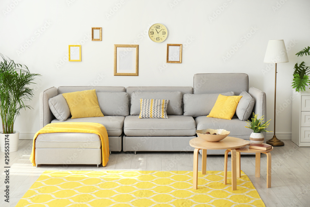 Stylish living room interior with comfortable grey couch - obrazy, fototapety, plakaty 