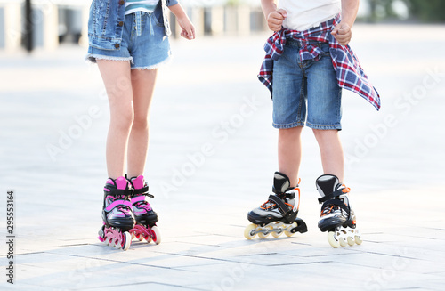 Little children roller skating on city street, closeup view