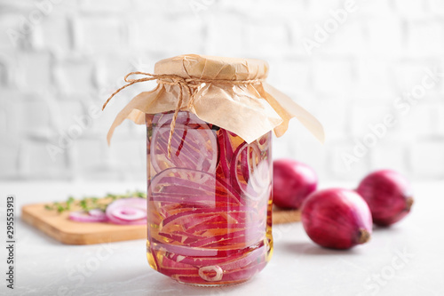 Jar of pickled onions on white table