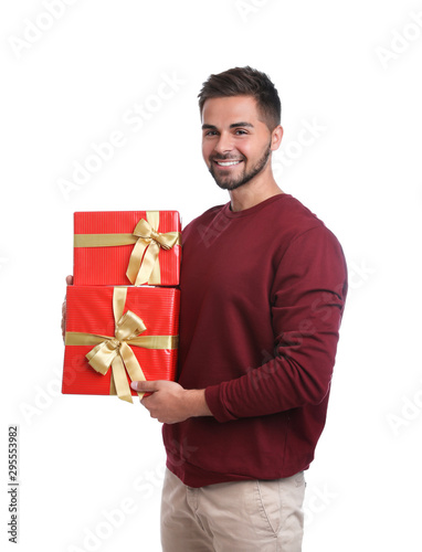 Happy young man holding Christmas gifts on white background