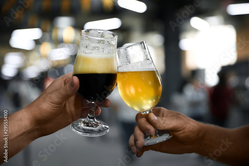Men with glasses of light and dark beer in bar  closeup