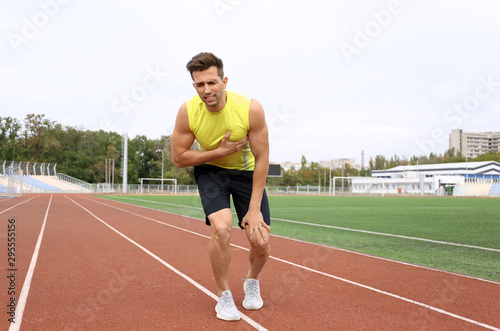 Young man having heart attack while running at stadium