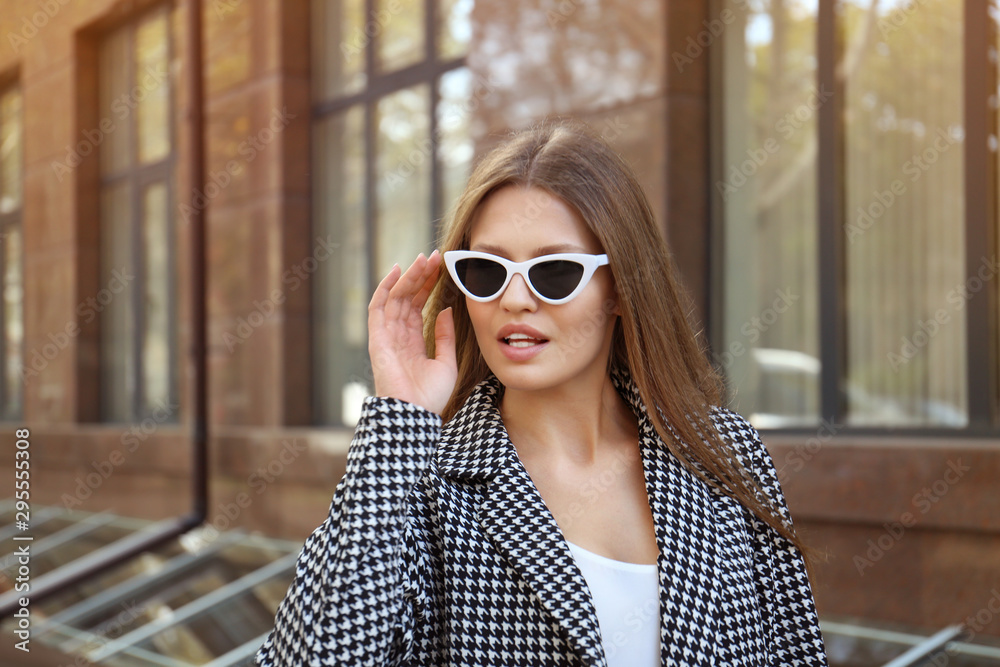 Young woman wearing stylish sunglasses on city street