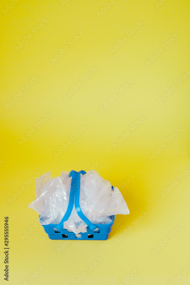 polythene bags in shopping basket on yellow background polythene bags in shopping basket on yellow background