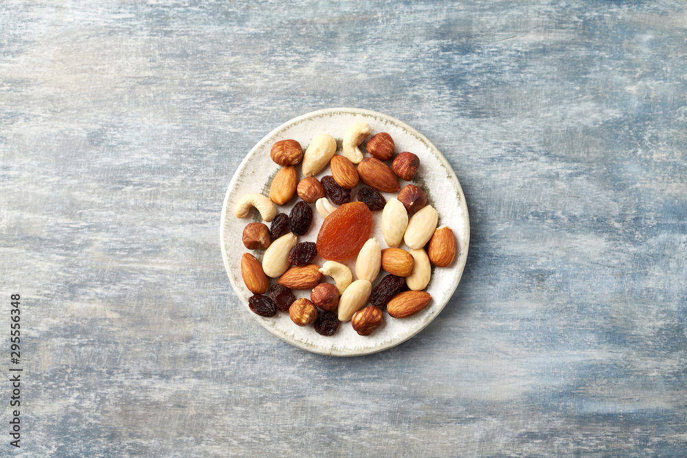 Nuts, raisins and apricots on rustic wooden background. Concept for healthy snack. Top view. Copy space. Nuts, raisins and apricots on rustic wooden background. Concept for healthy snack. Top view. Copy space.