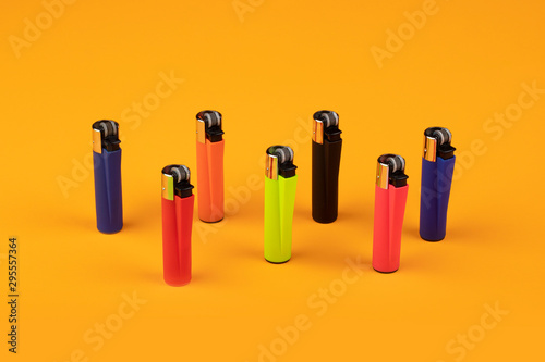 Multicolor gas lighters on orange background