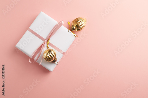 Christmas baubles and Christmas present. Bright paper background. Top view. Copy space.  photo