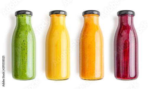 Green, yellow, orange and red smoothie in glass bottles