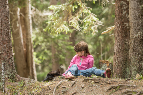 Mädchen sitzt auf Waldboden und fütter ein Eichhörnchen, Europäisches Eichhörnchen (Sciurus vulgaris)