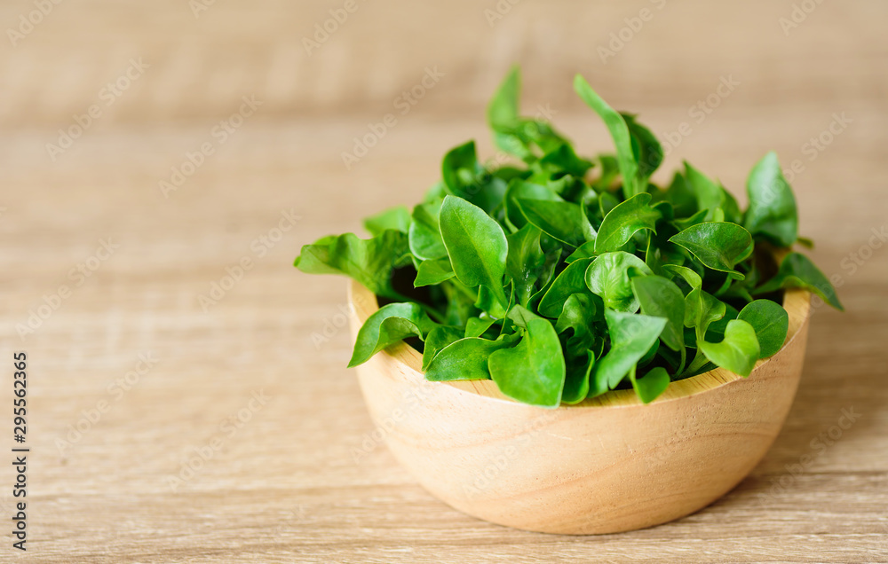Fresh watercress in a bowl on wooden background Fresh watercress in a bowl on wooden background
