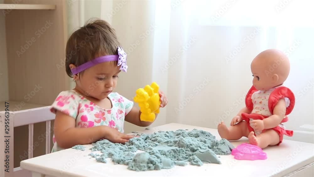 Small child in nursery playing with kinetic sand at white table HD Small child in nursery playing with kinetic sand at white table HD