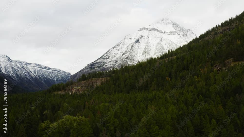 Aerial view of Glacier National Park, breathtaking landscapes of Montana, snowy mountain peaks and endless green forest, moody shoots of nature Aerial view of Glacier National Park, breathtaking landscapes of Montana, snowy mountain peaks and endless green forest, moody shoots of nature