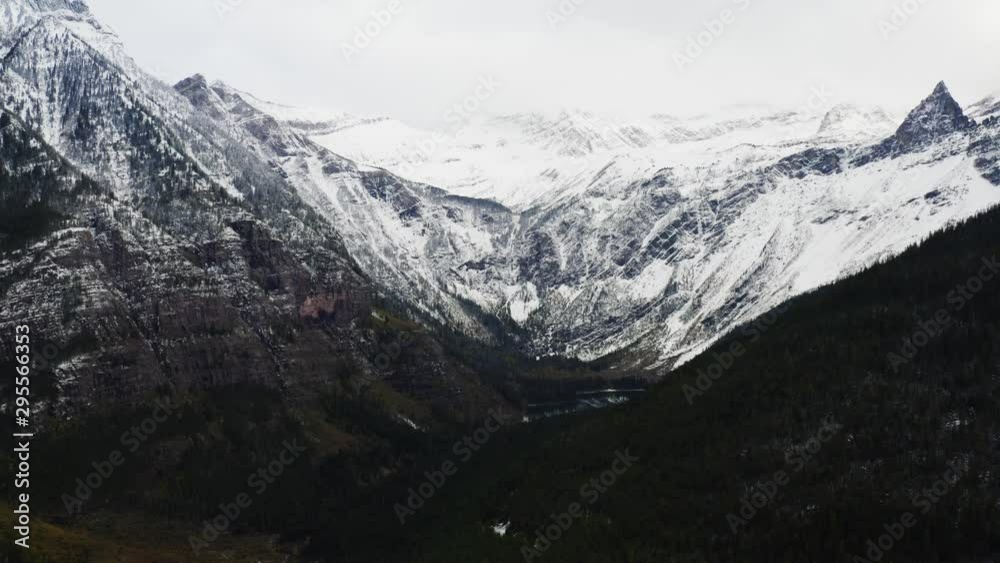 Aerial view of Glacier National Park, breathtaking landscapes of Montana, snowy mountain peaks and endless green forest, moody shoots of nature Aerial view of Glacier National Park, breathtaking landscapes of Montana, snowy mountain peaks and endless green forest, moody shoots of nature