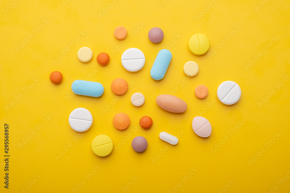 Top view colorful medical pills on yellow background. Top view colorful medical pills on yellow background.