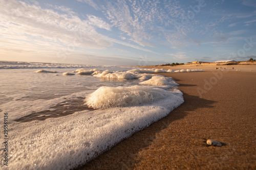 Seafoam Waves on the Beach with Blue Sky and Whispy Clouds on a Summer Morning