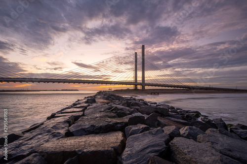 Bridge and Jetty at Sunset on a Calm Evening at the Beach with Orange Sky with Clouds photo