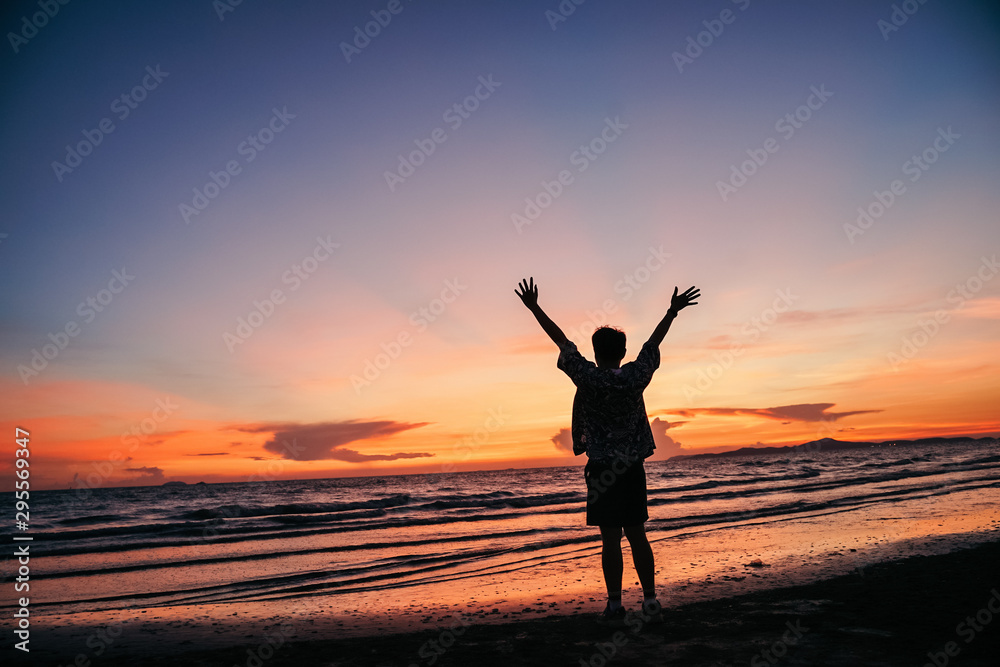 Happy man on the sunset in nature in summer with open hands