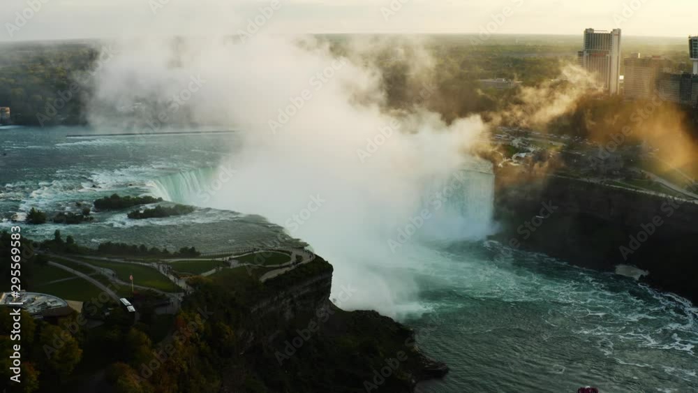 Aerial view of Niagara Falls, rocky edge of waterfall, sunset at famous destination of North America, nature of Northeast USA, fast water flow, dense fog Aerial view of Niagara Falls, rocky edge of waterfall, sunset at famous destination of North America, nature of Northeast USA, fast water flow, dense fog