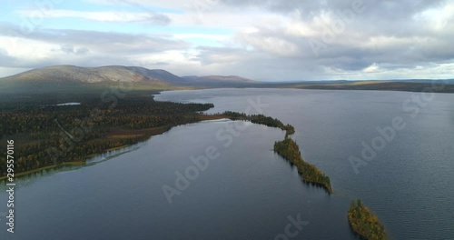 Pallas-Yllas national park, Aerial, reverse, drone shot, over the Pallasjarvi lake, overlooking islands, full of fall trees, Ounastunturit fells, on a sunny, autumn day, in Lapland, Finland photo