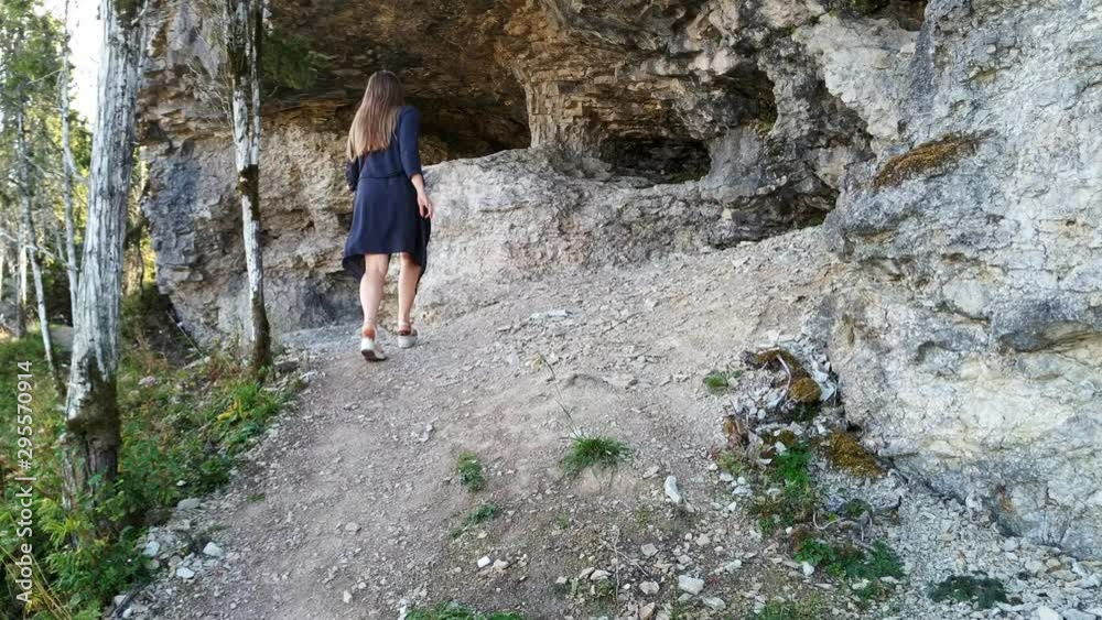 A woman hiking along the path alongside the Muhu Uugu in Estonia and touching the rocks A woman hiking along the path alongside the Muhu Uugu in Estonia and touching the rocks