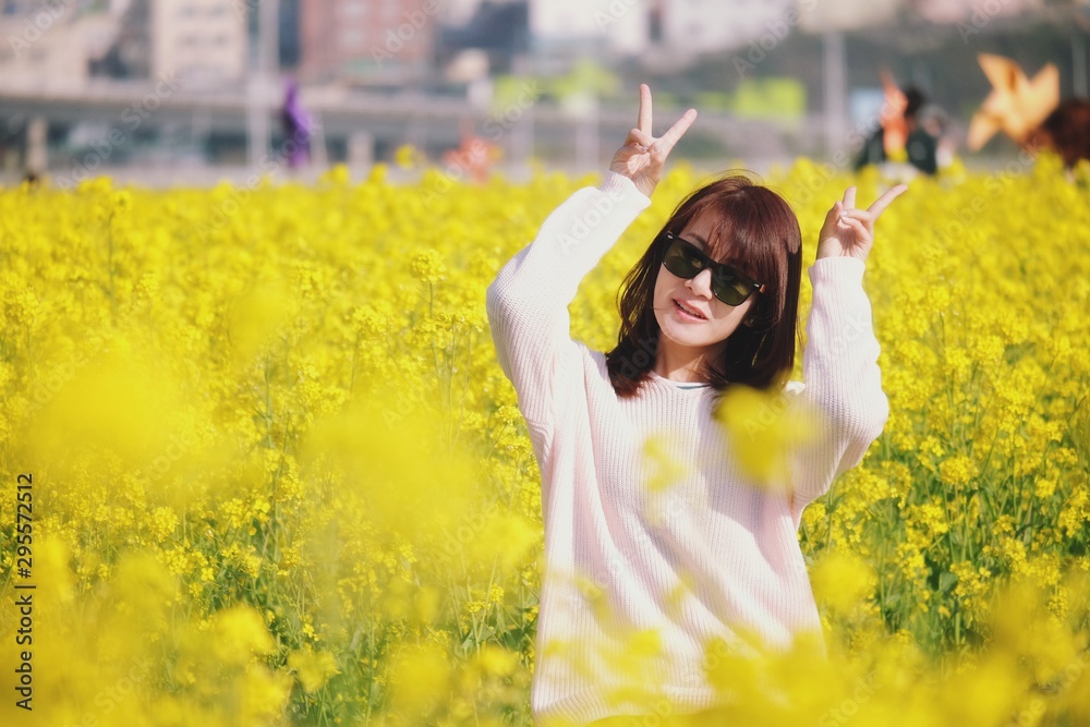 Happy women with black sunglasses and raise her hands in yellow flowers on nature summer at Busan, Korea. Happy women with black sunglasses and raise her hands in yellow flowers on nature summer at Busan, Korea.