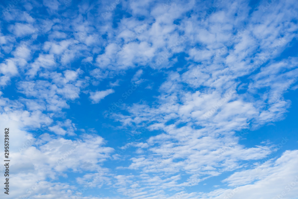 Blue sky and white fluffy clouds. Background. Wallpaper for the walls.