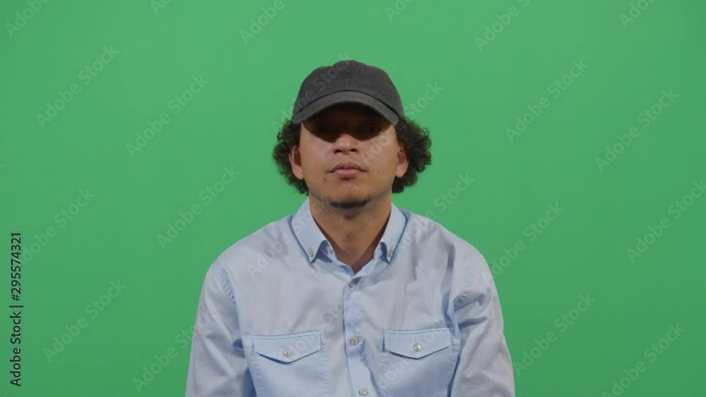 Adult Man Putting On A Sport Cap. Studio Isolated Shot Against Green Screen Background Adult Man Putting On A Sport Cap. Studio Isolated Shot Against Green Screen Background