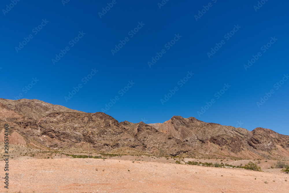 Bright blue sky without clouds and desert land and mountains at the botton. negative blue space for text Bright blue sky without clouds and desert land and mountains at the botton. negative blue space for text