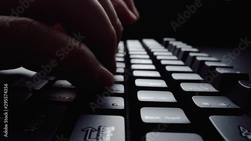 Close-up man typing on computer keyboard with hands and fingers. Macro soft focus dolly shot. Computer programming, text chat online messaging and online marketing business concept. photo