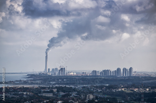 Aerial View of an Industrial Site emitting dark cloud of smoke into the air. Taken in Netanya, Center District, Israel.