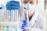 A male chemist holds test tube of glass