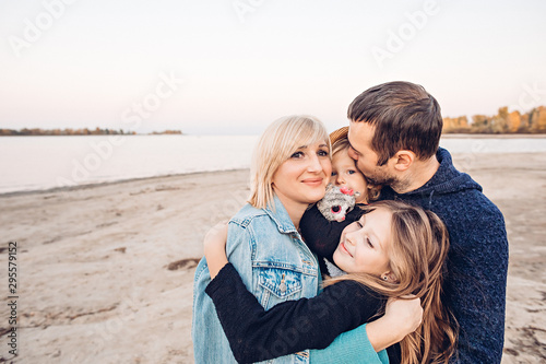 Happy family hugs by the river